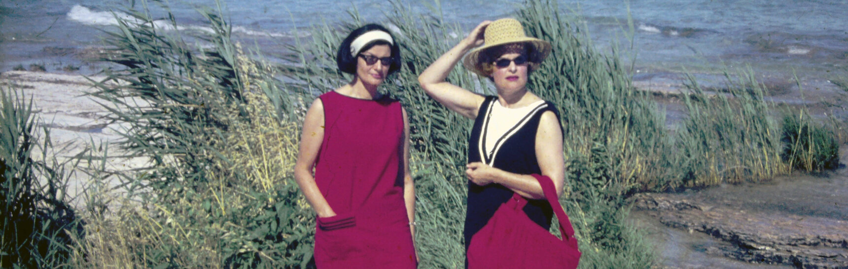 Ein Urlaubsdia mit zwei eleganten Grazer Damen an der Adriaküste mit roter Badetasche und rotem Kleid.