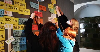 Museumsteam beim Hängen einer Wand voller bunter Moderationskarten