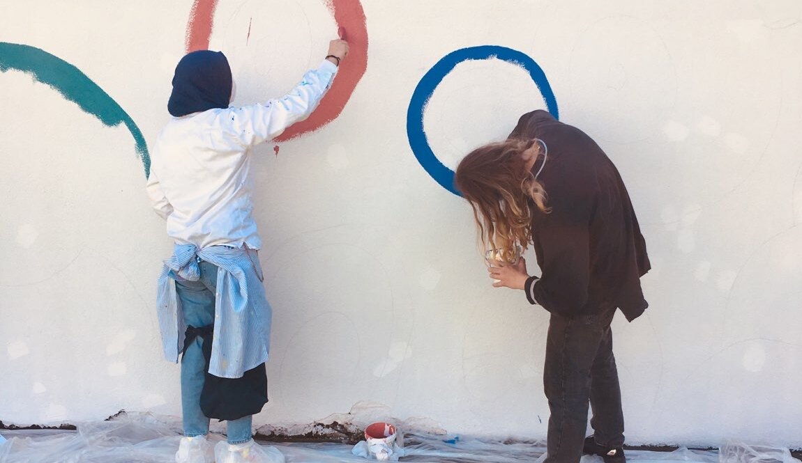 Zwei Schülerinnen sind dabei die Hofmauer ihrer Schule neu zu bemalen