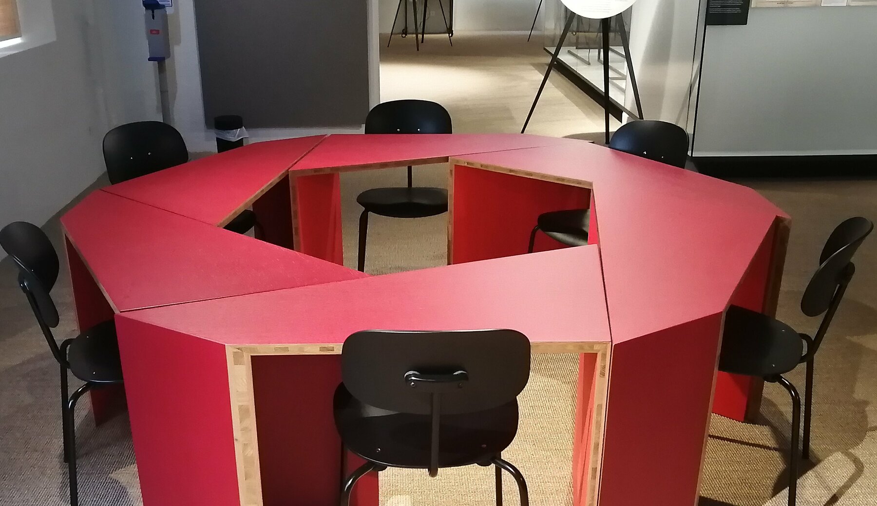 Das sogenannte Mitsprechzimmer im Volkskundemuseum: rote Tischelemente in einem Raum, die von Besucherinnen umgestellt und zum Austausch benutzt werden können