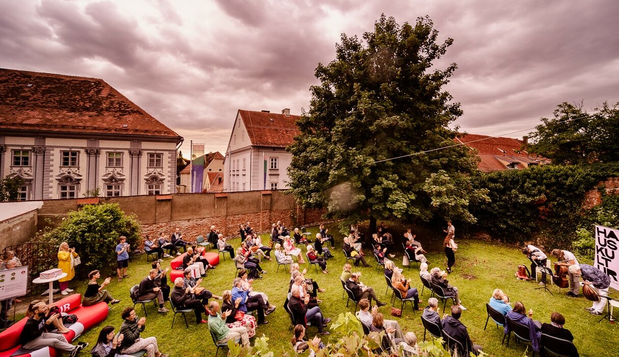 Konzert im Garten des Volkskundemuseums, Menschen sitzen auf Stühlen