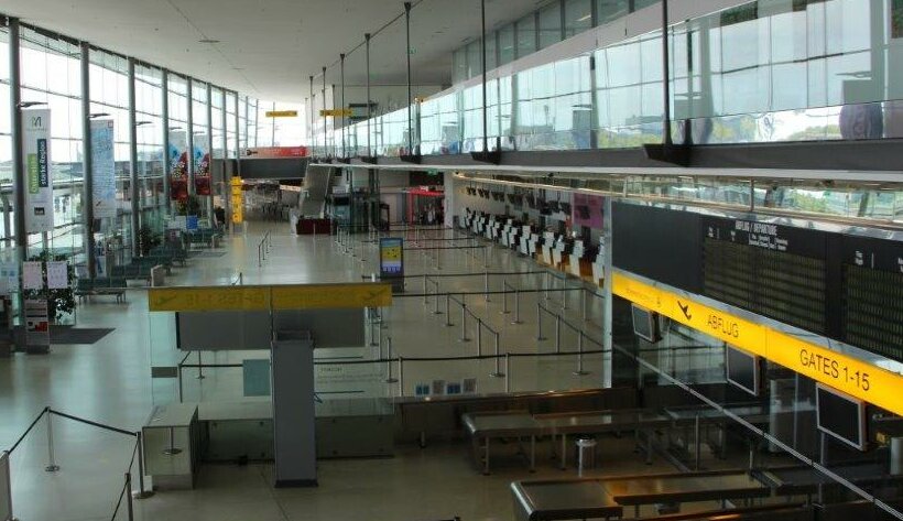 Stillgelegter Flughafen Graz während des ersten Covid-19-Lockdowns in Österreich, die Anzeigetafeln zeigen keine Flüge, die Halle ist menschenleer.